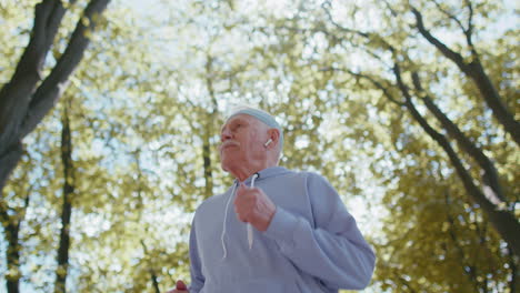 Motivated-athletic-fitness-retired-senior-old-man-running-in-park,-grandfather-healthy-active-sport