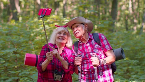 Senior-grandmother-grandfather-blogger-tourists-taking-selfie-photo-portrait-on-mobile-phone-in-wood