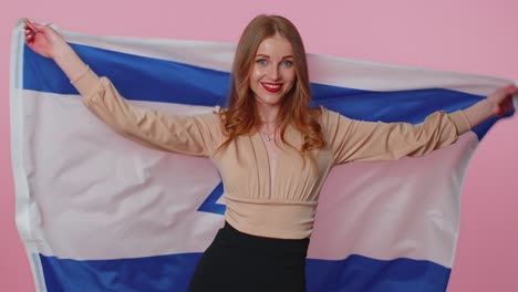 Alegre-Y-Encantadora-Adolescente-Ondeando-Y-Envolviendo-La-Bandera-Nacional-De-Israel,-Celebrando-El-Día-De-La-Independencia