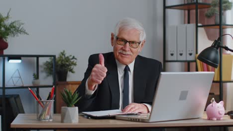 Senior-business-man-raises-thumbs-up,-agrees,-approve,-likes-good-news-using-laptop-at-home-office