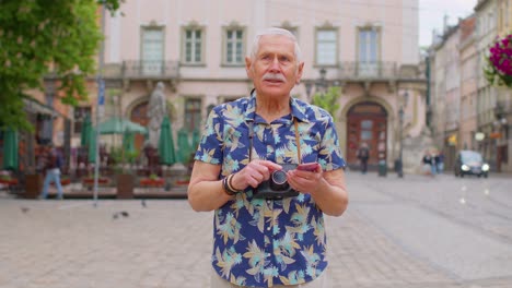 Anciano-Viajero-Abuelo-Pensionado-Perdiéndose-En-La-Ciudad,-Tratando-De-Encontrar-Una-Ruta-En-El-Teléfono-Móvil