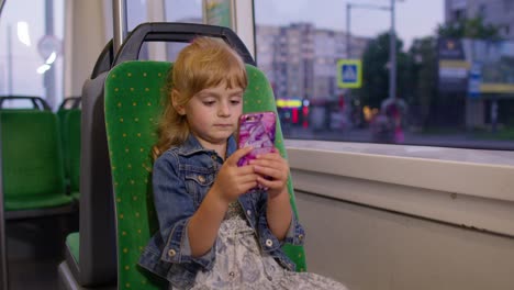 Mädchen-Spielt-Auf-Dem-Smartphone,-Chattet,-Schreibt-SMS,-Surft-In-Sozialen-Medien,-Während-Sie-Mit-Der-Straßenbahn-In-Die-Stadt-Fährt