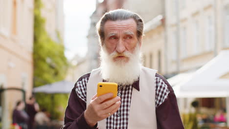 Älterer-Mann-Benutzt-Smartphone,-Um-Textnachrichten-Zu-Tippen-Und-Im-Internet-Zu-Surfen,-Um-Die-Arbeit-Zu-Beenden-Und-Online-Zu-Chatten