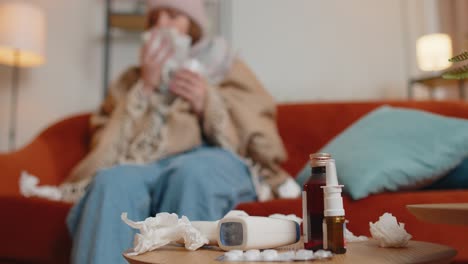 Sick-cold-woman-suffering-from-cold-or-allergy-at-home-in-living-room,-blows-nose-snot-into-napkin