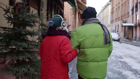 Senior-couple-tourists-grandmother-grandfather-walking,-traveling,-hugging,-embracing-in-winter-city