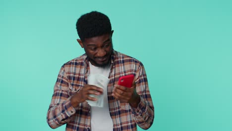 Fröhlicher-Afroamerikanischer-Mann-Mit-Handy-Display-Freut-Sich-Aufrichtig-über-Den-Gewinn-Und-Erhält-Geld-In-Dollar