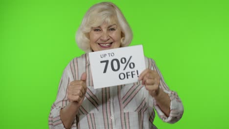 Senior-grandmother-showing-Up-To-70-percent-Off-inscription-sign,-rejoicing-discounts.-Chroma-key