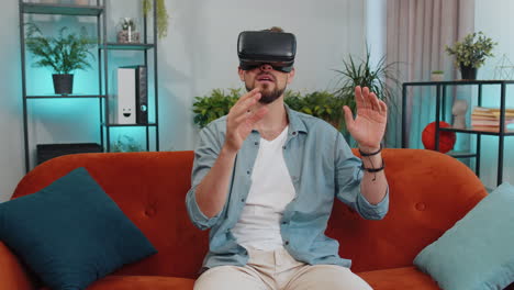 Hombre-Que-Usa-Auriculares-De-Tecnología-Futurista-De-Realidad-Virtual-Para-Jugar-Videojuegos-De-Simulación-3d-En-Casa