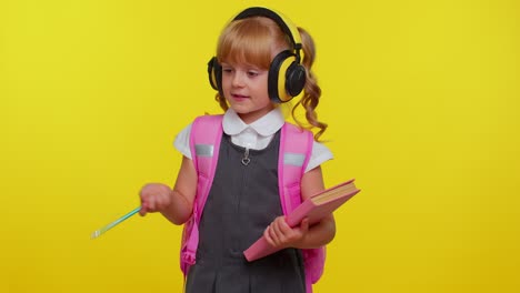 Pretty-smiling-girl-in-school-uniform-listening-music-via-headphones,-dancing-disco-fooling-around