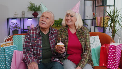 Glücklicher-älterer-Familienvater-Und-Frau,-Die-Geburtstag-Und-Jahrestag-Feiert,-Halten-Cupcake-Und-Wünschen-Sich-Etwas-Zu-Hause