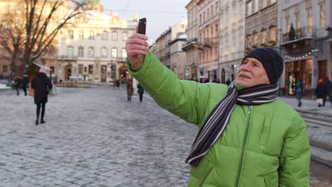 Älterer-Mann,-Großvater,-Touristen,-Die-Zu-Fuß-Unterwegs-Sind-Und-Selfie-Bilder-In-Einer-Europäischen-Winterstadt-Machen