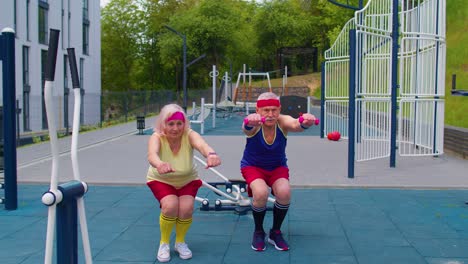 Senior-grandmother-and-grandfather-sports-team-doing-squatting-fitness-exercising-on-playground