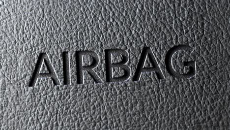 Closeup-of-a-safety-airbag-sign-in-the-car’s-dark-leather-upholstery.-Dashboard-texture-lit-by-soft-light-showing-intricate-details-of-texture.-Best-automobile-passengers-protection-during-an-accident