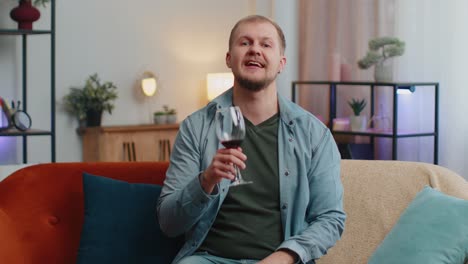 Glücklicher-Junger-Erwachsener-Mann-Trinkt-Rotweinglas-Und-Feiert-Geburtstag-Jahrestag-Lottogewinn-Zu-Hause