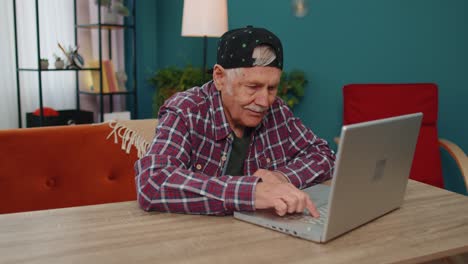 Überglücklicher-älterer-Großvater-Mit-Laptop-Feiert-Erfolg-Und-Gewinnt-Geld-Im-Online-Lotto-–-Gute-Nachrichten