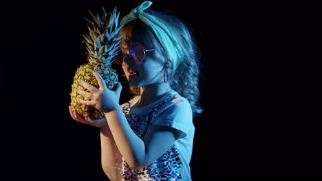 Trendy-stylish-girl-in-sunglasses-with-pineapple-singing,-fooling-around-at-disco-cyberpunk-club