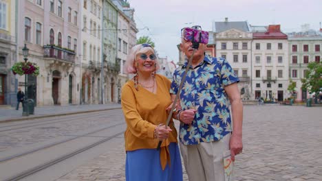 Elderly-stylish-blogger-tourists-man-woman-taking-selfie-photo,-making-video-call-on-mobile-phone