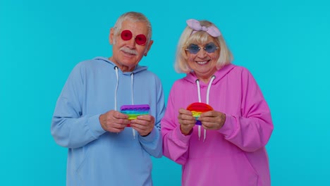 Ältere,-Glückliche-Großmutter,-Großvater,-Der-Spielt-Und-Drückt,-Anti-Stress-Push-Pop-it-populäres-Spielzeugspiel