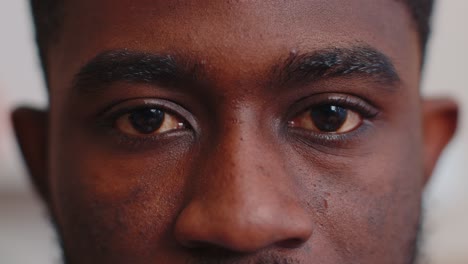 Close-up-macro-portrait-of-beauty-young-african-american-man's-eyes,-smiling-model-looking-at-camera