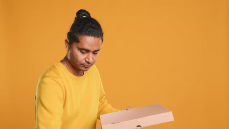 Portrait-of-pizza-delivery-man-holding-takeaway-boxes,-studio-background