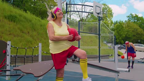 Ältere-Frau-Großmutter-Nach-Dem-Sport-Basketball-Training-Sitzen-Und-Musik-Auf-Dem-Spielplatz-Hören