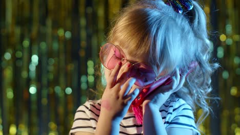 Mädchen-In-Futuristischer-Brille-Telefoniert-Mit-Mutter-In-Einem-Nachtclub-Mit-Neonblauem-Licht