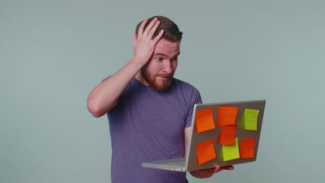 Exhausted-man-freelancer-with-pasted-sticker-notes-using-laptop-computer,-concentration-problem