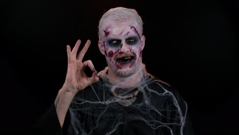 Creepy-man-Halloween-zombie-showing-Ok-gesture,-like-sign-positive-something-good,-smiles-terribly