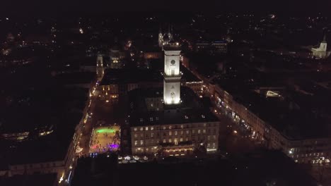 Ciudad-Arial-Lviv,-Plaza-Rynok-De-Ucrania,-Ayuntamiento,-Feria-De-Navidad,-La-Gente-Patina-En-Una-Pista-De-Patinaje-Sobre-Hielo