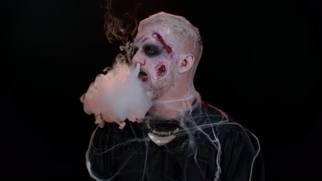 Creepy-man-scary-wounded-bloody-scars-face-Halloween-undead-guy-blows-smoke-from-nose,-smiles