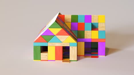 Colorful-house-being-build-from-a-pile-of-colorful-wooden-blocks.-Camera-position-pans-around-it.-Construction,-development-of-preschool-kid’s-building-imagination.-Fun-with-learning-aspects.
