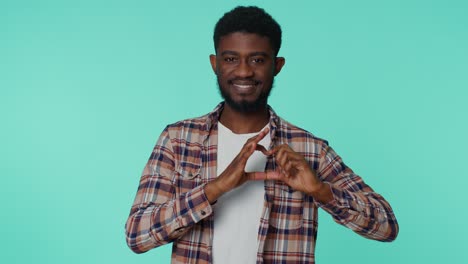 Smiling-african-american-man-makes-heart-gesture-demonstrates-love-good-sign-feelings-and-sympathy