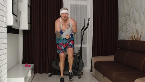 Funny-man-athlete-sportsman-guy-with-beard-makes-workout-running,-having-fun,-fooling-around-at-home
