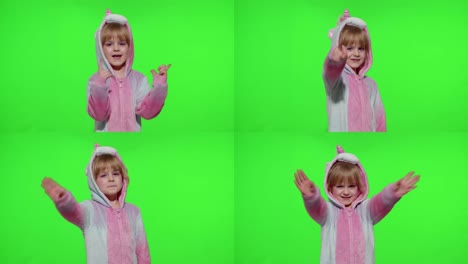 Little-child-girl-smiling,-waving-greeting,-hello-or-bye-with-hand-in-unicorn-pajamas-on-chroma-key