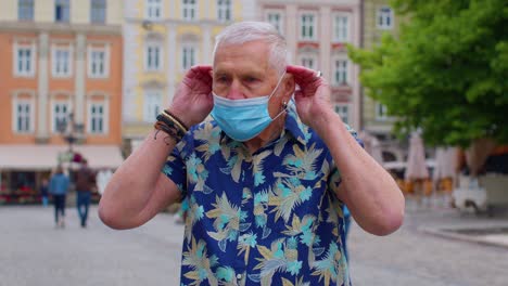 Coronavirus-pandemic,-portrait-of-senior-stylish-tourist-man-grandfather-wearing-protective-mask