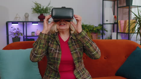 Mujer-Mayor-Usando-La-Aplicación-De-Casco-VR-Para-Jugar-Juegos-De-Simulación-Viendo-Videos-De-Realidad-Virtual-En-Casa