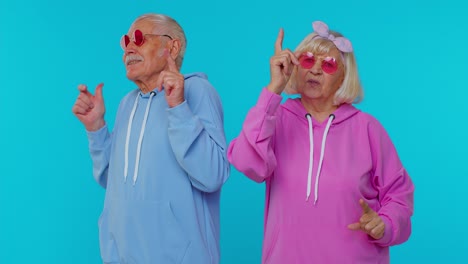 Lovely-senior-couple-man-woman-grandparents-listening-music-dancing-disco-fooling-around-having-fun