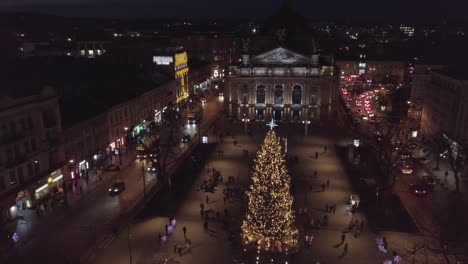 Arial-view-of-Lviv-Christmas-tree-near-Opera-house,-Festive-lights,-and-Fair-market-on-winter-night