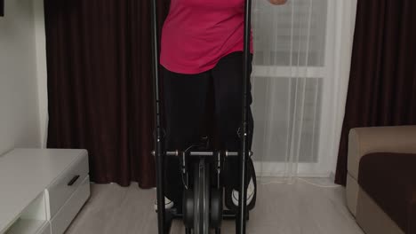 Active-healthy-senior-old-mature-woman-in-sportswear-using-orbitrek,-training-cardio-workout-at-home