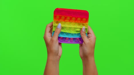 Hands-playing-popular-squishy-silicone-bubbles-sensory-toy-game-isolated-on-chroma-key-background