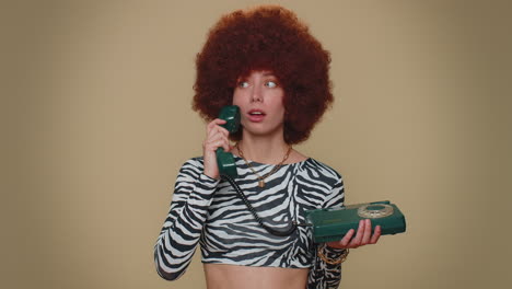 Pretty-woman-with-brown-lush-wig-talking-on-wired-vintage-telephone-of-80s-says-hey-you-call-me-back