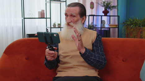 Grandfather-man-taking-selfie-on-smartphone-communicating-video-call-home-online-with-subscribers