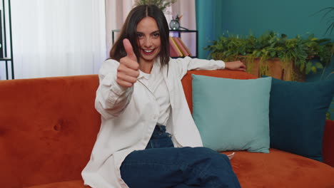 Happy-young-woman-looking-approvingly-at-camera-showing-thumbs-up,-like-positive-sign,-good-news