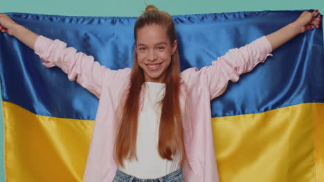 Teen-young-girl-hold-Ukraine-national-flag-hoping-for-success,-independence,-freedom,-victory-in-war