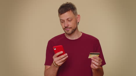 Glücklicher-Mann-Benutzt-Smartphone,-Plastikkreditkarte,-Surft-Und-Sagt-„Wow,-Ja“,-Findet-Einen-Großen-Gewinn
