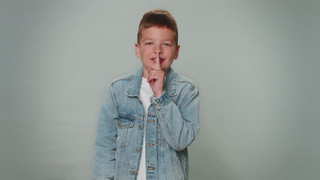 Boy-child-presses-index-finger-to-lips-makes-silence-gesture-sign-do-not-tells-secret,-shh-be-quiet