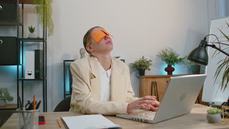 Ineffiziente-Müde-Faule-Geschäftsfrau,-Die-Am-Laptop-Arbeitet-Und-Mit-Augenaufklebern-Im-Gesicht-Schläft
