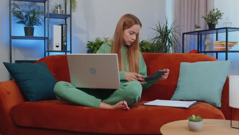 Junge-Geschäftsfrau-Arbeitet-Mit-Laptop-Computer-Und-Dokumenten-Und-Plant-Zu-Hause-Das-Ausgabenbudget