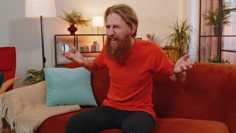 Bearded-ginger-man-asking-why,-what-reason-of-failure-demonstrating-disbelief-irritation-by-troubles