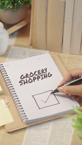 VERTICAL-VIDEO-OF-TICKING-OFF-GROCERY-SHOPPING-WORK-FROM-CHECKLIST